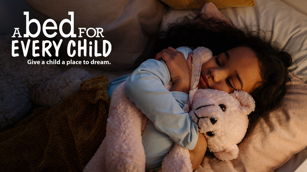 child sleeping and holding teddy bear
