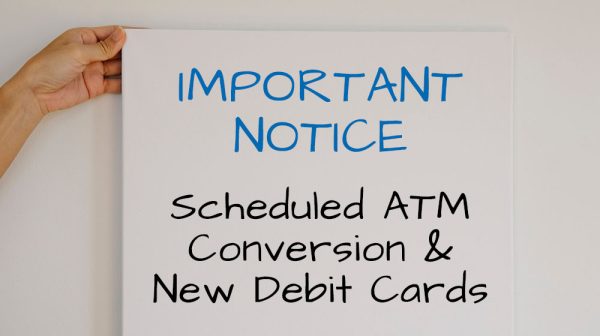 Hands holding a sign that reads: Important Notice: Scheduled ATM Conversion