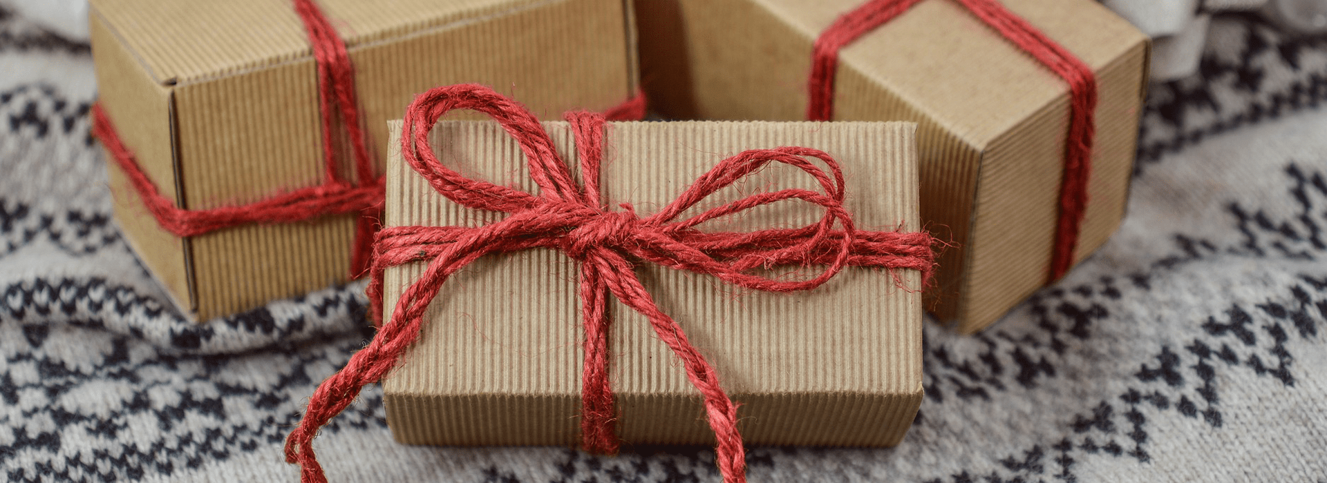 Three small packages wrapped in red ribbon.