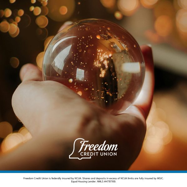 Hand holding a crystal ball under holiday lights