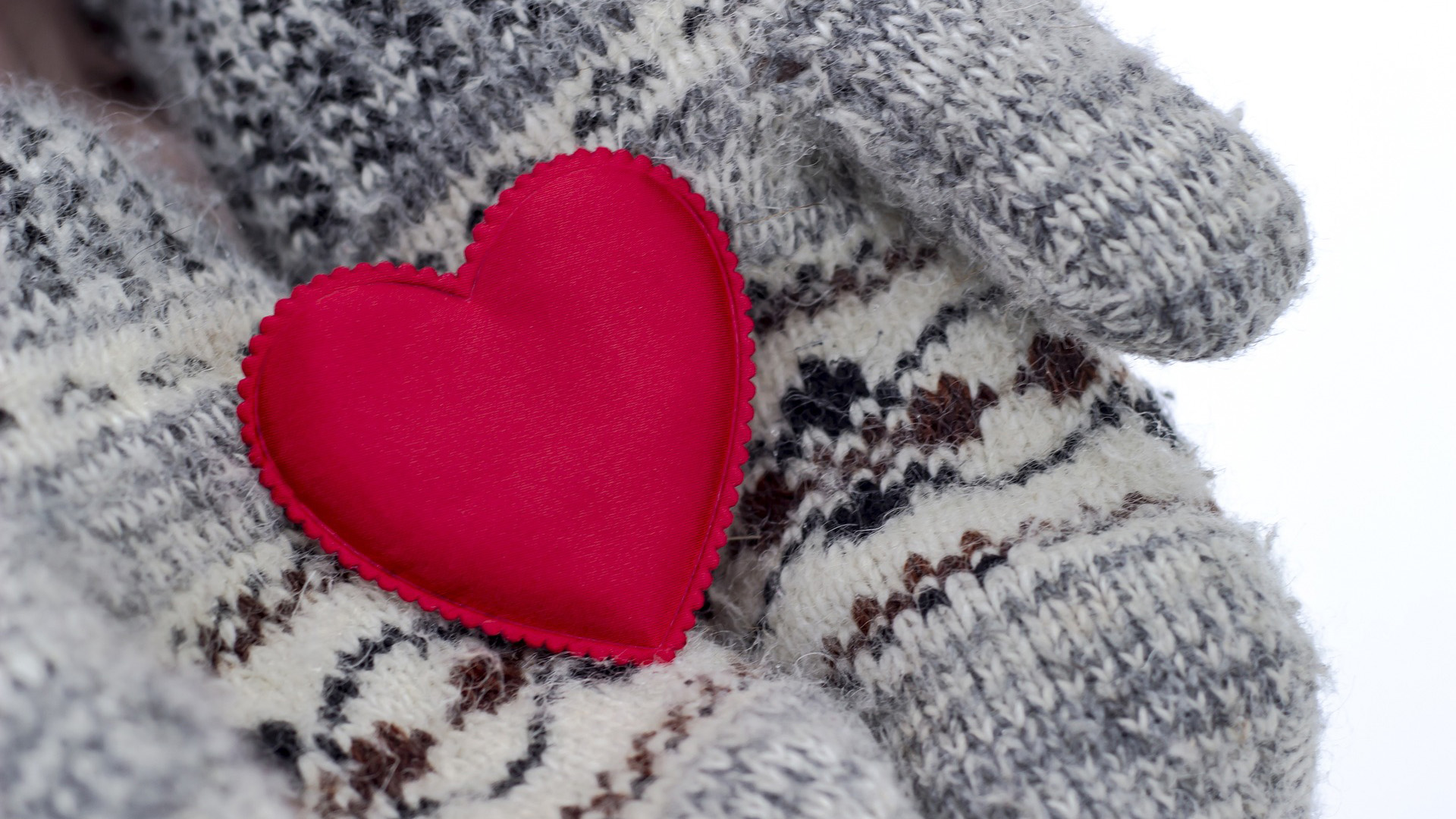 Mittened hands holding a felt heart