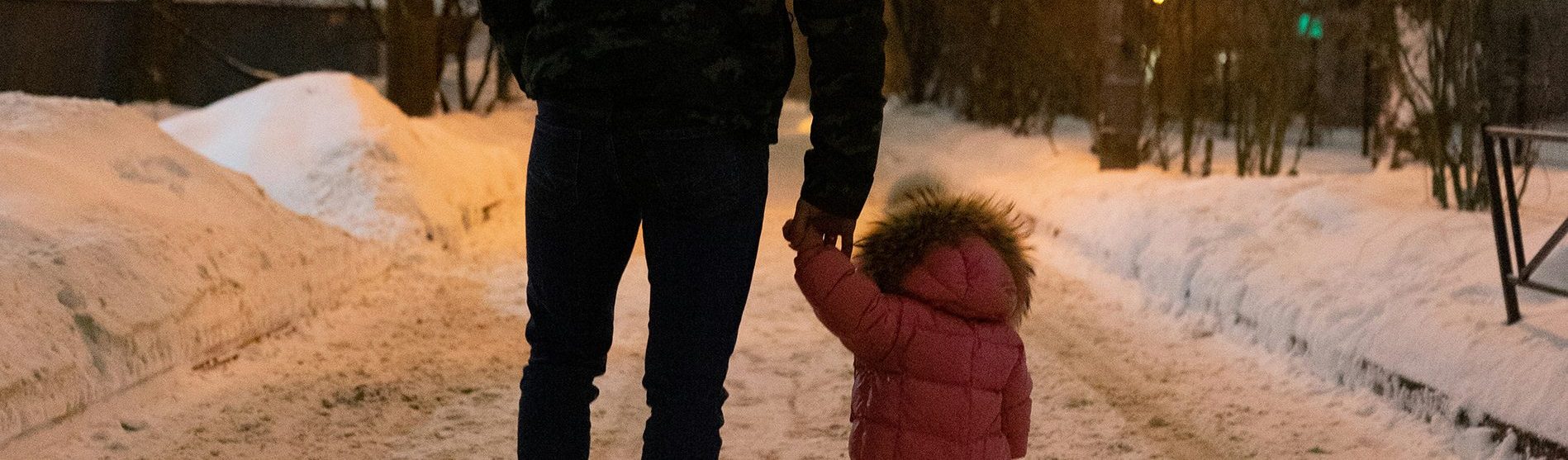 man and child walking down a snowy street