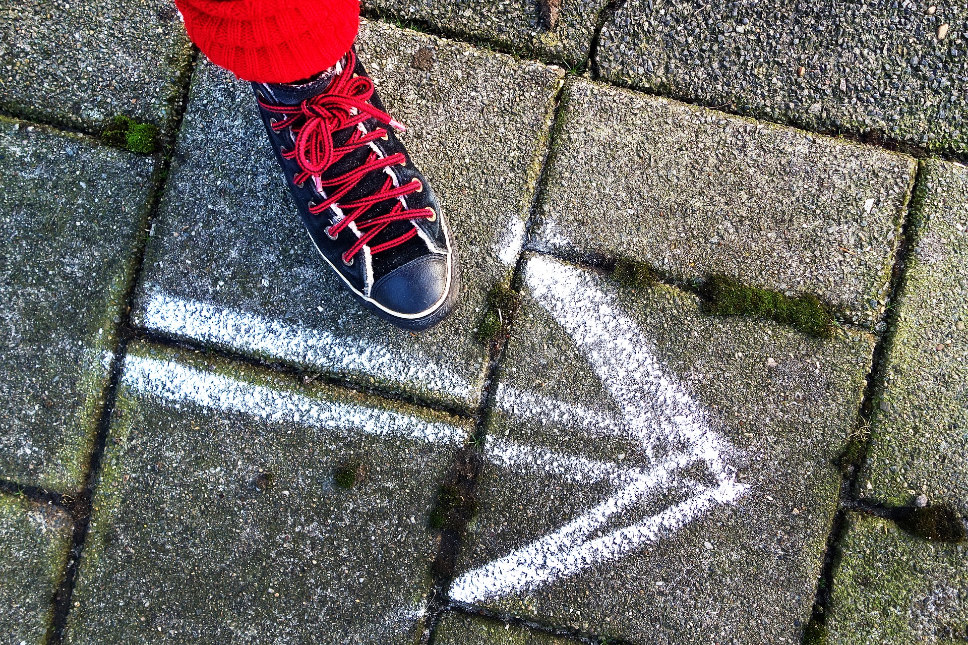 shoe next to chalk arrow on ground